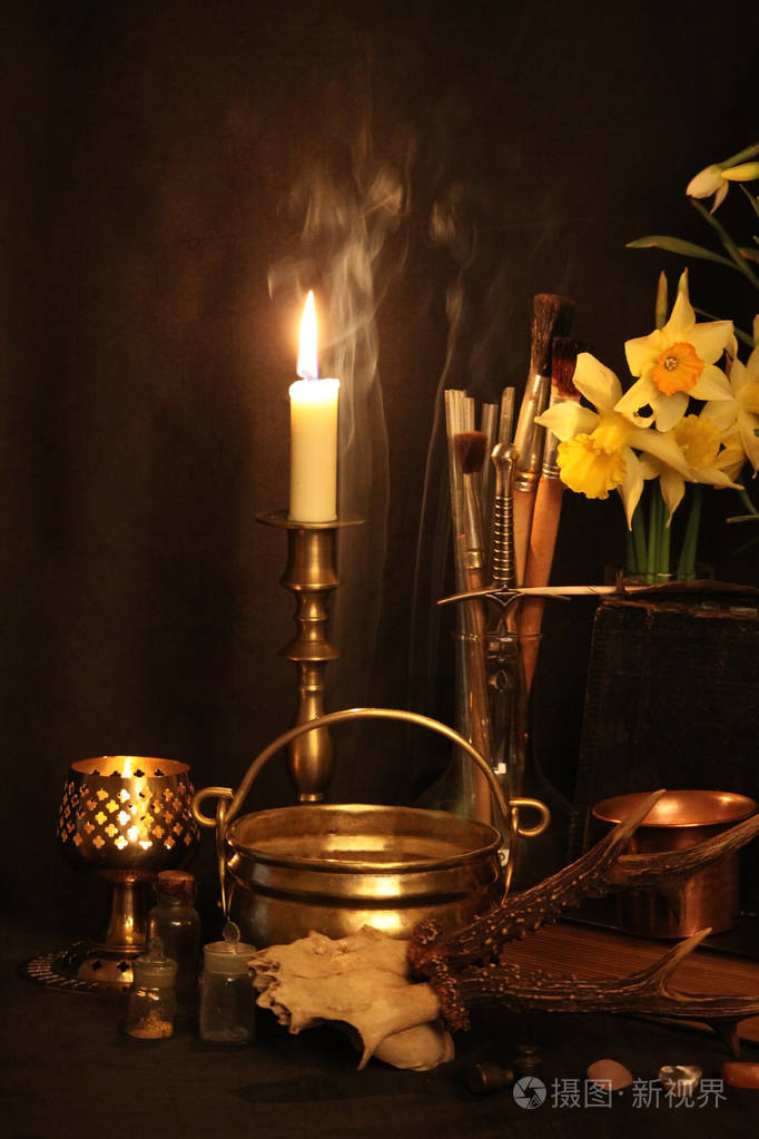 还活着:旧的油灯,古董书,干燥的玫瑰花蕾,一支燃烧的蜡烛,在铜碗药瓶