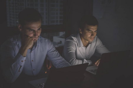 商业加班概念. 一群在夜间加班的商人. 商人对办公室工作很认真.