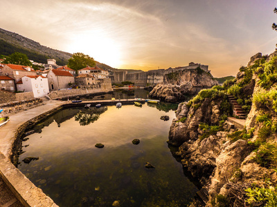 美丽的景色俯瞰着历史悠久的老城镇和城市墙壁的杜布罗夫尼克克罗地亚日出与一个安静的小海湾亚得里亚海的前景。
