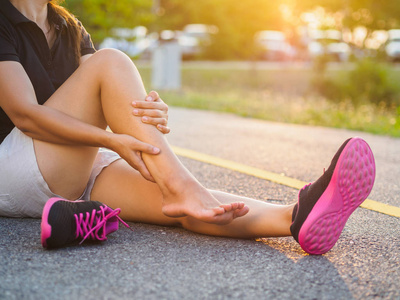 跑步伤害腿事故运动女子跑步者受伤，手疼，扭伤脚踝。 女性运动员关节或肌肉酸痛，下身有问题感疼痛。