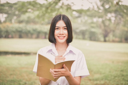 教育观念。 美丽的学生在公园里看书。 美丽的女孩在公园里放松。 年轻的学生很乐意读书。 年轻的学生喜欢学习。 亚洲妇女的教育。