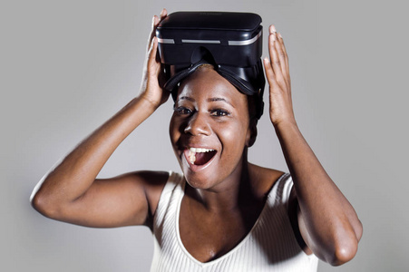 年轻有吸引力和快乐的黑人美国妇女展示VR3D视觉护目镜后，享受惊人的体验，玩和乐趣的虚拟现实电子游戏在孤立的背景下。