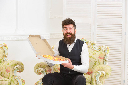男子气概的经典服装饥饿和兴奋举行奶酪比萨饼, 吃, 享受香气, 室内背景。胡子和胡子的男人拿着美味的新鲜热披萨盒。比萨送货理念