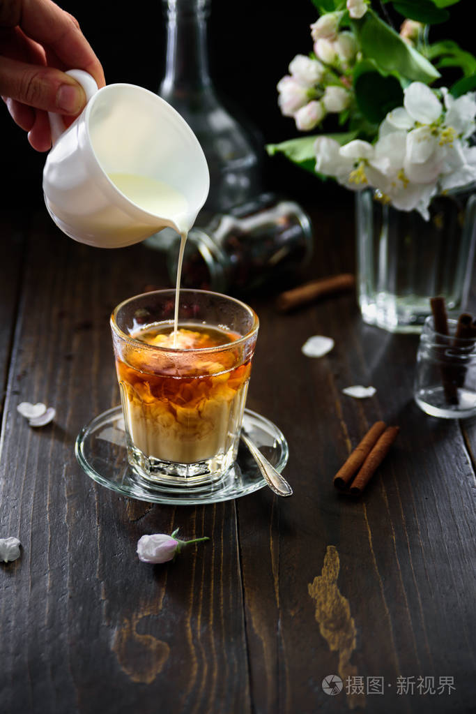 一杯红茶上面有肉桂牛奶和苹果花