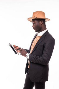年轻英俊的非洲裔美国商人西装革履，时髦的人在互联网上使用平板电脑冲浪，或者查看隔离在白色上的电子邮件