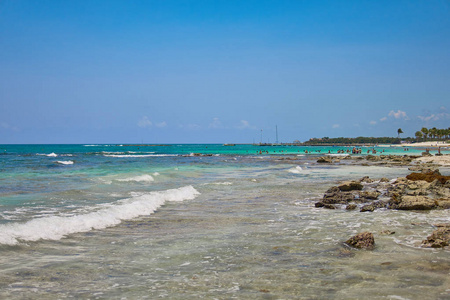 在热带海岸豪华度假村酒店查看。椰树的叶子在风中飘扬在蓝天上。加勒比海的绿松石水。海滨玛雅墨西哥
