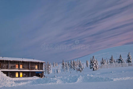 被雪和日出覆盖的房子