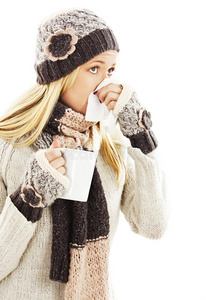 并用患流感并用手帕擤鼻涕的年轻妇女照片