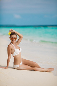 在热带海滩享受阳光的年轻女性