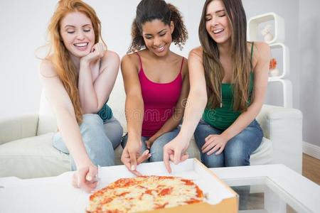 快乐的年轻女性朋友在家吃披萨