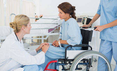 医生在医院和坐轮椅的病人谈话