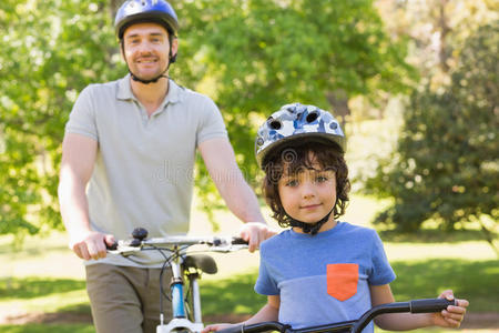 带着儿子骑自行车的微笑的男人