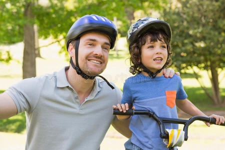 带着儿子骑自行车的微笑的男人