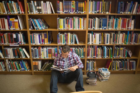 集中年轻学生坐在图书馆地板上阅读