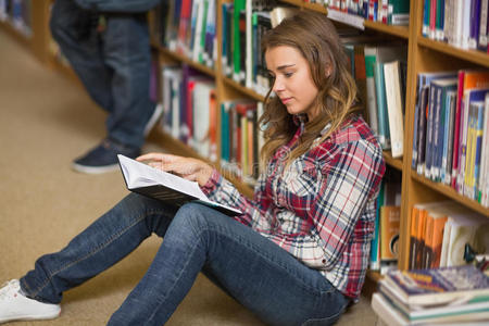 快乐的学生在图书馆的地板上看书