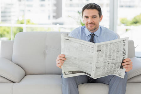 一位衣着光鲜的男子读报的画像