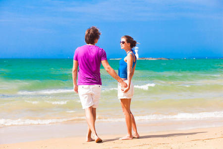 穿着亮丽衣服的夫妇在热带海滩举行