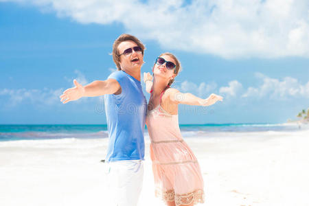 一对穿着鲜艳衣服的夫妇在热带海滩上微笑
