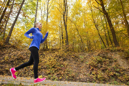 秋日自然中活泼好动的女跑步者