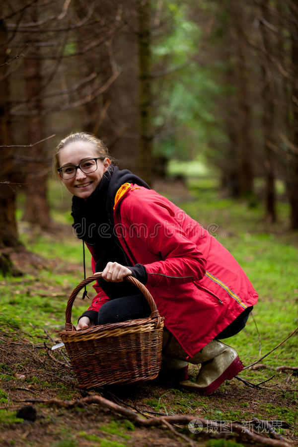在森林里采蘑菇的年轻女子