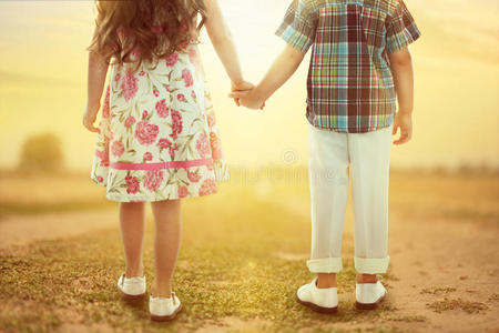 日落时分孩子们手牵手的背影照片