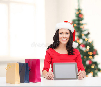 带平板电脑的圣诞帽微笑女士