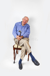 微笑的老人拿着拐杖坐在椅子上