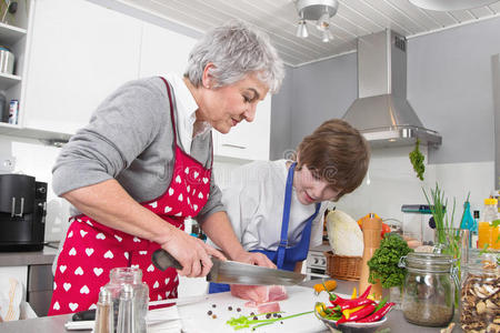 祖母教小男孩在家做饭家庭生活。