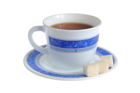 一杯茶和精制糖放在白色的碟子上