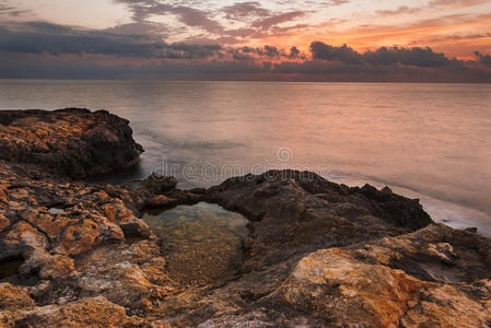 落日的岩石海滩