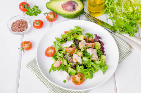 新鲜沙拉与鸡牛油果西红柿和亚麻籽在一个盘子白色木制背景。 健康的食物。