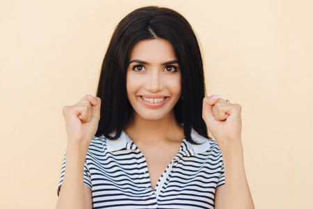 双手托起希望坦率的镜头开朗的黑发年轻女性有很大的希望,双手握拳