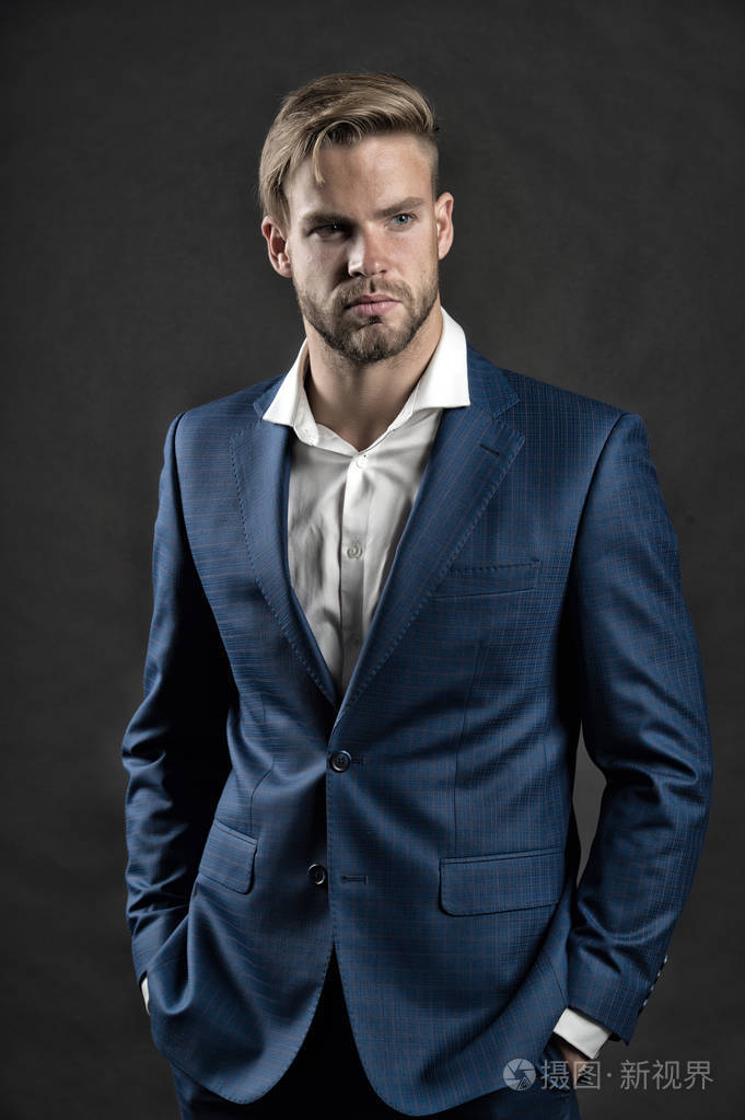 商人有吸引力的关心外表.男人胡子严脸的发型, 深色的背景.