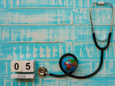 六月五日木块日历地球仪和听诊器的蓝色木制背景。