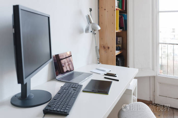 家庭办公室桌上的电脑笔记本和数码平板电脑照片