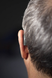 聋人老人佩戴现代数字高科技助听器。