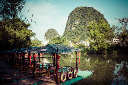 桂林阳朔县绿林和喀斯特山间沿玉龙河航行的小型旅游竹筏的风景。 阳朔是亚洲一个受欢迎的旅游目的地。