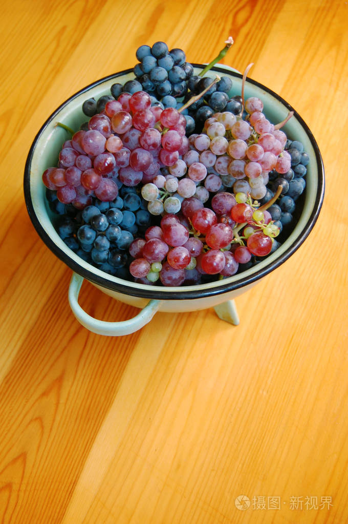 把成熟的五颜六色的葡萄串放在盘子里