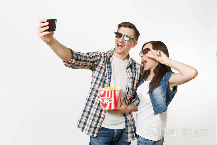 年轻夫妇戴着3d眼镜看电影约会时拿着一桶爆米花一杯苏打水或可乐在