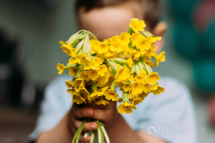 那个男孩犹豫着躲在一束模糊的黄花后面给妈妈的礼物给一束花礼物模糊
