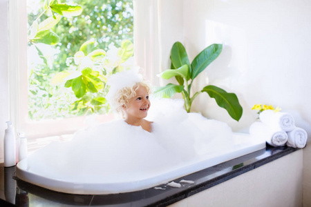 孩子们的卫生. 儿童洗发水,头发处理和肥皂. 孩子在大浴缸里洗澡.