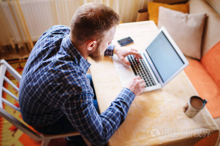 在办公室上网自信的年轻人在笔记本电脑上工作坐在办公室的工作场所