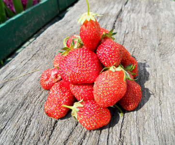 照片为全熟浆果红色草莓，绿色茎叶..草莓摄影，由水果，生的，甜的，收获的作物，分离在背景上。吃美味的新鲜草莓