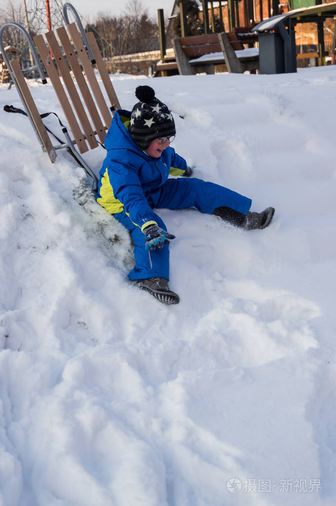 一个小男孩在冬天玩雪橇