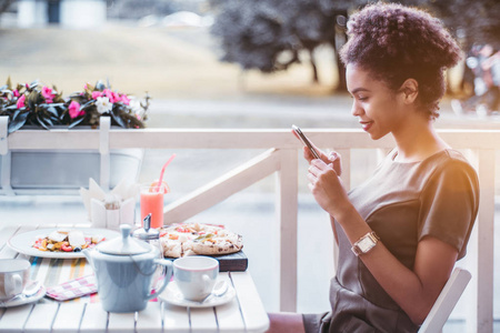  a young cute black female is taking photos of her pizza via cam