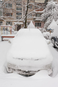 在冬天的暴风雪中，停车场里被雪覆盖的车辆