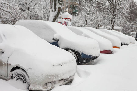 在冬天的暴风雪中，停车场里被雪覆盖的车辆