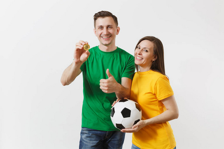 微笑的年轻夫妇，男人，足球迷，穿着黄绿色T恤，振作起来，支持队与足球比特币金币隔离在白色背景上。 体育家庭休闲生活方式概念