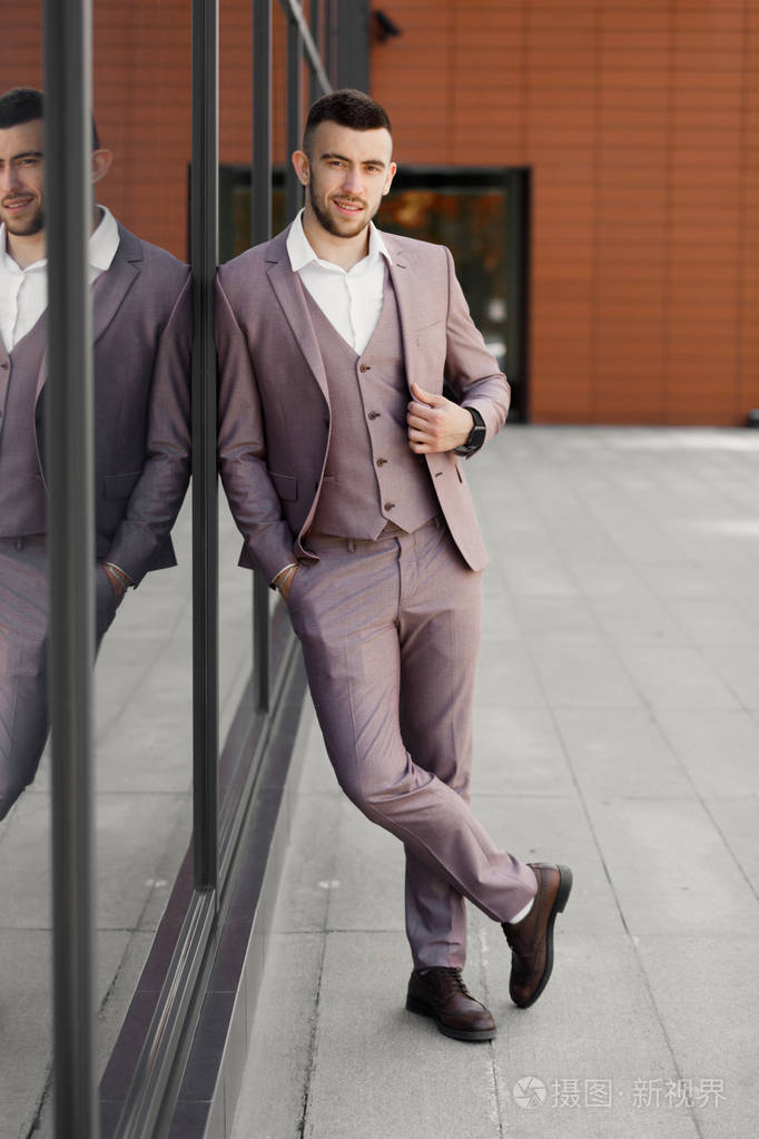 商人在城市现代商人自信的年轻人穿着全套衣服站在户外