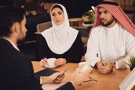阿拉伯夫妇在治疗师招待会上喝咖啡。 家庭心理学家的概念。 去看治疗师。